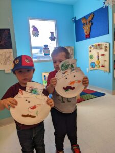 Two children with snowmen crafts.