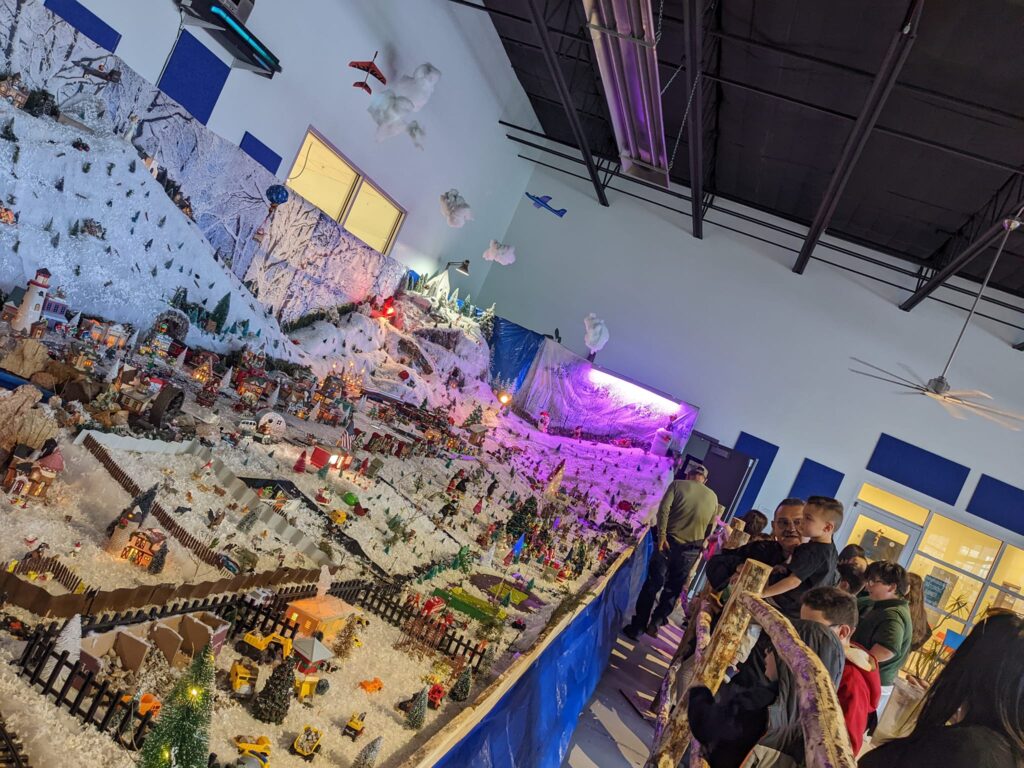 Families looking at the model train village. 