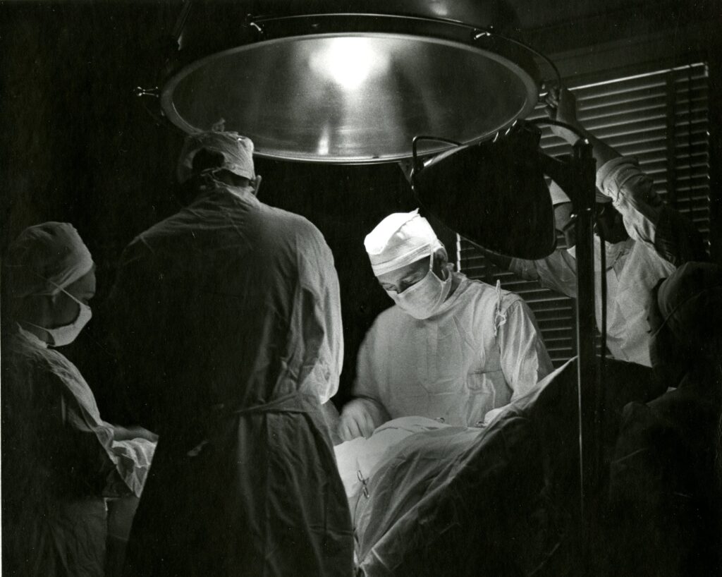 Black and white image of a surgeon in an operating room.